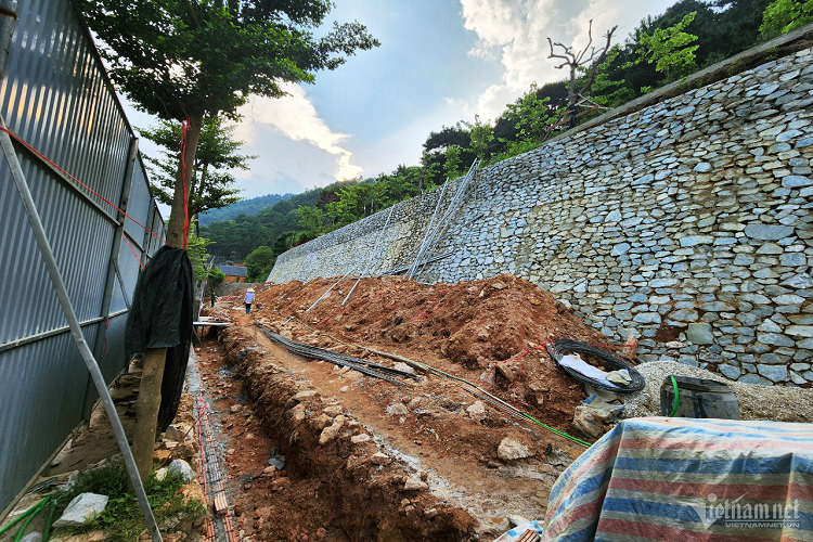 Nhiều tháng nay, đoạn chân núi dài khoảng 200m ven hồ Đồng Đò (xã Minh Trí) bị đào bới để xây bờ kè đá cao khoảng 4m. Vào mùa mưa lũ, đi qua đoạn đường này, nhiều người lo ngại sạt lở bất cứ lúc nào do bờ kè đá dựng đứng, mong manh, không chống chọi được với sức tàn phá nếu có mưa lũ. 