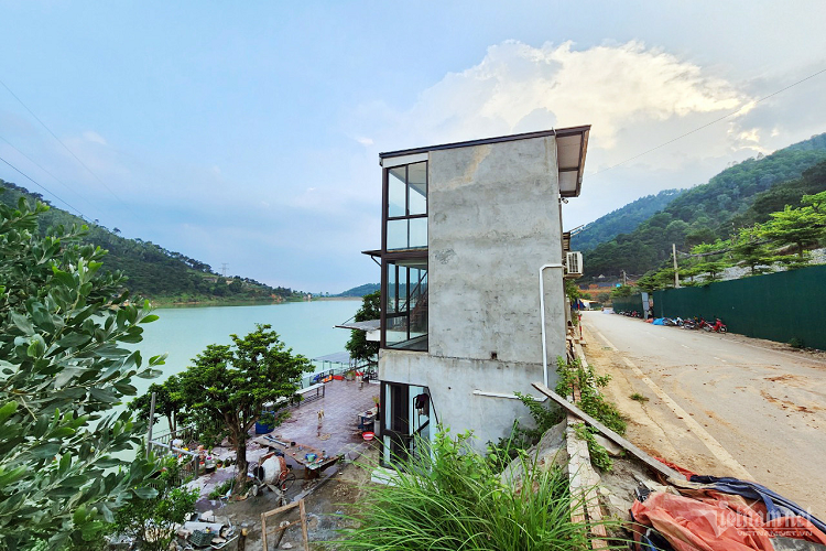 Một công trình 3 tầng nằm bên mép hồ Đồng Đò. Người dân đưa máy móc vào san gạt đất, đá dưới chân núi để mở đường đi vào các biệt thự, homestay nằm ven hồ Đồng Đò. 