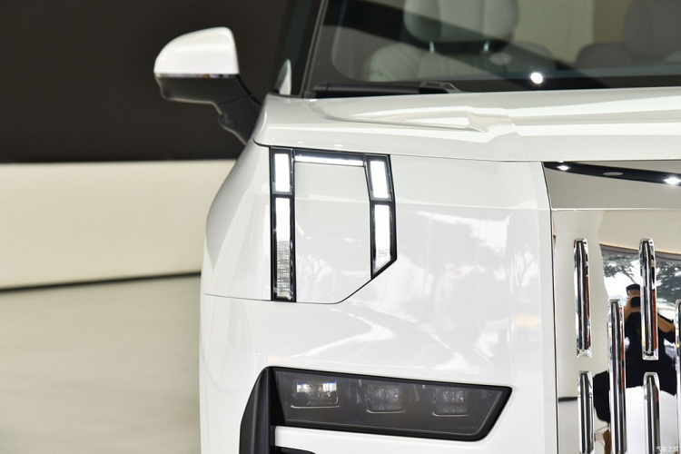 Zeekr 009 cũng mang trên mình thiết kế nổi bật, thậm chí là "đập vào mắt" bất kỳ ai, đặc biệt là khu vực đầu xe. Tại đây, mẫu MPV Trung Quốc này được trang bị lưới tản nhiệt đóng kín và đi kèm những rãnh nằm dọc. Lưới tản nhiệt của xe có thể mạ crôm hoặc sơn cùng màu với thân xe, tùy theo lựa chọn của khách hàng. Thiết kế lưới tản nhiệt này khiến người ta không khỏi liên tưởng đến dòng SUV siêu sang Rolls-Royce Cullinan.