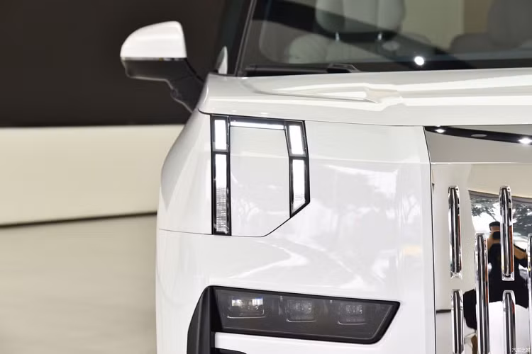 Zeekr 009 cũng mang trên mình thiết kế nổi bật, thậm chí là "đập vào mắt" bất kỳ ai, đặc biệt là khu vực đầu xe. Tại đây, mẫu MPV Trung Quốc này được trang bị lưới tản nhiệt đóng kín và đi kèm những rãnh nằm dọc. Lưới tản nhiệt của xe có thể mạ crôm hoặc sơn cùng màu với thân xe, tùy theo lựa chọn của khách hàng. Thiết kế lưới tản nhiệt này khiến người ta không khỏi liên tưởng đến dòng SUV siêu sang Rolls-Royce Cullinan.