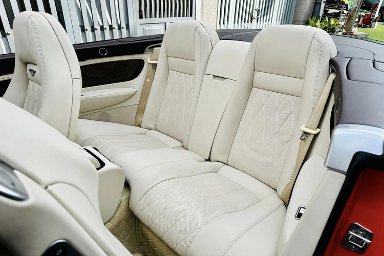 Tiếp đó, ta sẽ thấy bảng điều khiển trung tâm của chiếc Bentley Continental GTC 2008 này có gỗ ốp màu đen bóng, và quan trọng, màn hình giải trí nhỏ của xe nguyên bản đã biến mất, thay vào đó là màn hình cảm ứng siêu to, đặt dọc, thiết kế như xe Tesla.