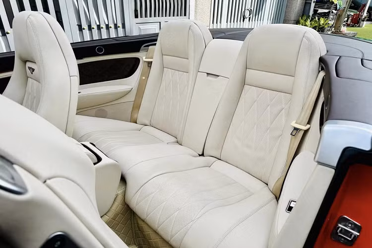 Tiếp đó, ta sẽ thấy bảng điều khiển trung tâm của chiếc Bentley Continental GTC 2008 này có gỗ ốp màu đen bóng, và quan trọng, màn hình giải trí nhỏ của xe nguyên bản đã biến mất, thay vào đó là màn hình cảm ứng siêu to, đặt dọc, thiết kế như xe Tesla.