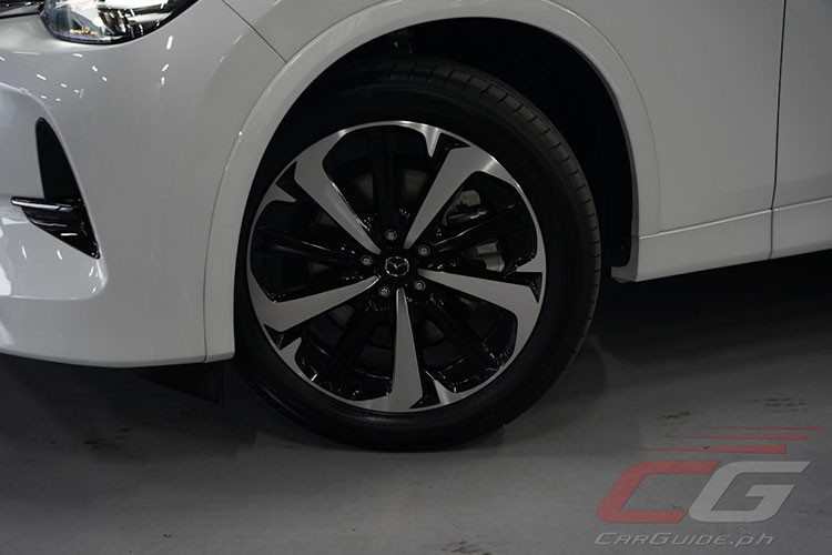 Thay vì những điểm nhấn sáng bóng trên xe, gói Premium Sport lại mang đến viền lưới tản nhiệt và nẹp trang trí màu đen trên chắn bùn trước. Ngoài ra, với gói Premium Sport, Mazda CX-60 2024 còn được trang bị những chi tiết mạ crôm màu tối trên lưới tản nhiệt, bộ vành hợp kim 20 inch.