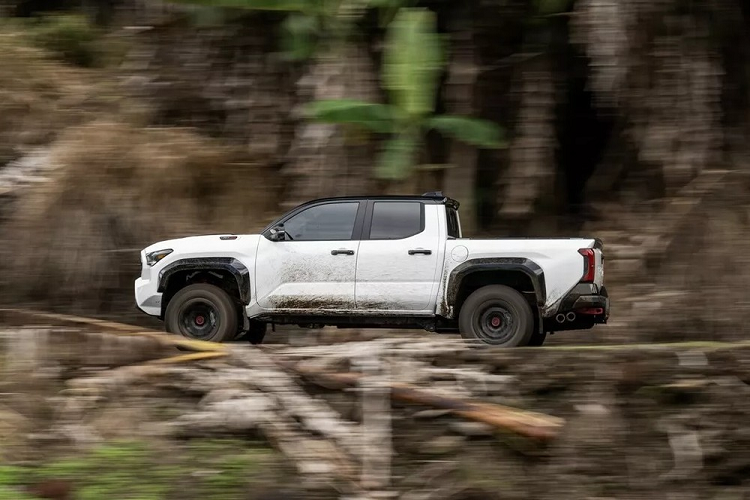 Tương tự bản Trailhunter mới, Toyota Tacoma TRD Pro 2024 cũng có một số đặc điểm nhận dạng như lưới tản nhiệt hình lục giác tích hợp dòng chữ "Toyota" thay vì logo quen thuộc của hãng và dải đèn LED bổ sung. Tiếp đến là ốp cua lốp mở rộng và cản sau bằng thép với móc cứu hộ màu đỏ.