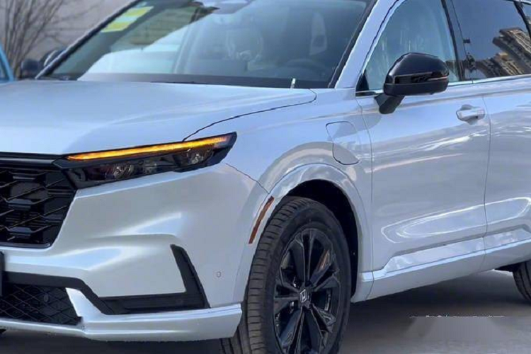 Trong khi đó, thiết kế của Honda CR-V e:PHEV 2023 không khác biệt nhiều so với phiên bản máy xăng và hybrid của mẫu SUV cỡ C này. Xe cũng được trang bị lưới tản nhiệt cỡ lớn với mắt lưới hình tổ ong thể thao sơn màu đen, tích hợp logo màu xanh dương của hãng Honda. Bên cạnh đó là cụm đèn pha LED sắc sảo, tích hợp dải đèn LED định vị ban ngày.