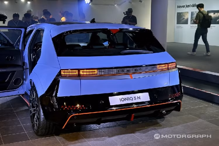 Chưa hết, mẫu ôtô điện Hàn Quốc còn có ốp màu đen tương phản trên sườn xe. Những điểm nhấn màu cam Luminous Orange được áp dụng cho cả cản trước, cản sau lẫn bên sườn. Ở cản sau còn có thêm đèn phản quang với tạo hình bàn cờ. Không chỉ thay đổi thiết kế, Hyundai Ioniq 5 N 2024 còn dài hơn 80 mm so với bản thường nhờ bộ khuếch tán gió sau.
