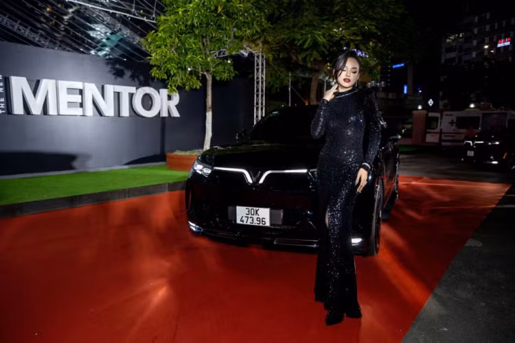 Mai Ngô khoe dáng trong bộ đầm đen quý phái, toát lên vẻ bí ẩn quyến rũ “tông xuyệt tông” cùng “giao diện” của SUV điện VinFast VF9. Màu sơn Granite Black huyền bí cùng dải đèn LED hình cánh chim phóng khoáng đặc trưng của hãng xe Việt tạo cảm hứng cho các ngôi sao The New Mentor tự tin khoe dáng.