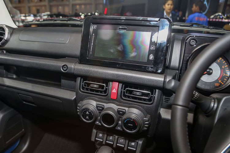Vô lăng Jimny tương tự Suzuki XL7 tại Việt Nam, màn hình giải trí 7 inch tích hợp Android Auto/Apple CarPlay, định vị vệ tinh, kết nối Bluetooth, hệ thống âm thanh 2 loa. Hệ thống chỉnh gương, cân bằng điện tử hay hỗ trợ đổ đèo đều được đặt ở bảng điều khiển trung tâm. 