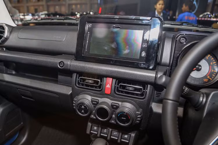 Vô lăng Jimny tương tự Suzuki XL7 tại Việt Nam, màn hình giải trí 7 inch tích hợp Android Auto/Apple CarPlay, định vị vệ tinh, kết nối Bluetooth, hệ thống âm thanh 2 loa. Hệ thống chỉnh gương, cân bằng điện tử hay hỗ trợ đổ đèo đều được đặt ở bảng điều khiển trung tâm. 