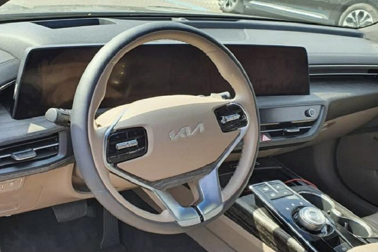 Bảng điều khiển trung tâm của K8 được thiết kế công thái học với kiểu dáng nhô lên phía sau, bộ điều chỉnh điều hòa đặt ngay phía dưới màn hình cong, cần số dạng núm xoay gọn gàng và nút bấm sưởi ghế, sưởi vô lăng ngay cạnh cần số. Kia K8 tự hào là mẫu xe đầu tiên của thương hiệu Hàn được trang bị hệ thống âm thanh vòm 14 loa Meridian - thường thấy trên các thương hiệu ôtô cao cấp.