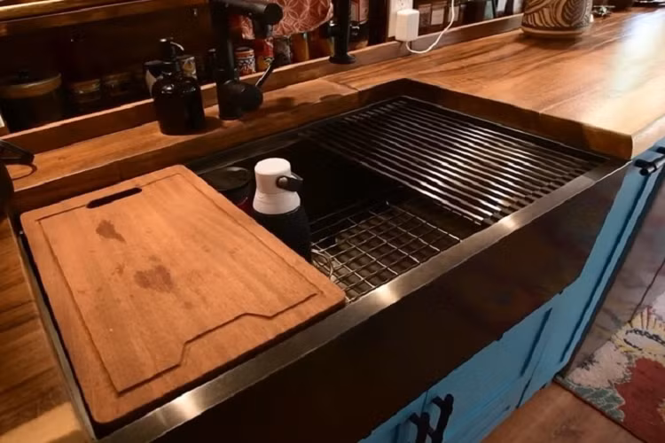 Trong bếp đã có nồi chiên không dầu, bếp điện... Khu vực chứa đồ ăn được giấu phía sau cửa lùa nhà tắm. Tủ lạnh và tủ đông cũng được tích hợp sẵn trên chiếc xe buýt cũ chở học sinh độ nhà di động.