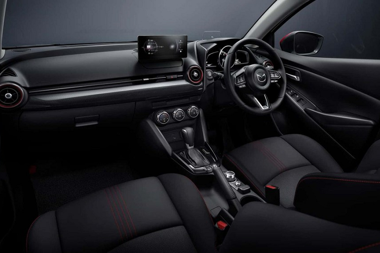 Màn hình của Mazda2 2024 vẫn có thiết kế như máy tính bảng và đặt nổi thay vì tích hợp gọn gàng vào mặt táp-lô. Với hệ thống thông tin giải trí mới, người dùng có thể thực hiện các cuộc gọi khẩn cấp hoặc tư vấn, định vị xe và điều khiển một số tính năng từ xa thông qua điện thoại thông minh.