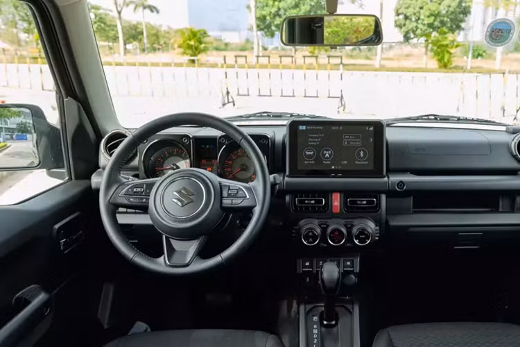 Gần hốc bánh trước có sự xuất hiện của xi-nhan, gắn trực tiếp vào thân xe. Bánh dự phòng được được gắn trực tiếp lên cửa sau. Đèn phanh và xi-nhan được đặt khá thấp, khiến phương tiện di chuyển phía sau khó quan sát. Bước vào bên trong, khoang cabin của Suzuki Jimny đem tới cảm giác quen thuộc.