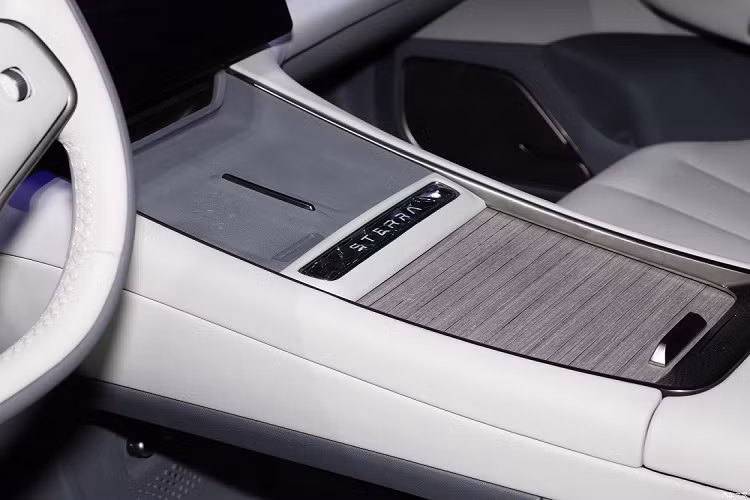 Trước mặt người lái là vô lăng 2 chấu với logo "Exeed" ở giữa, bảng đồng hồ kỹ thuật số nhỏ và màn hình cảm ứng trung tâm cỡ lớn đặt nổi trên mặt táp-lô. Trên cụm điều khiển trung tâm chỉ có 2 sạc điện thoại không dây và hộc đựng cốc có nắp che ốp gỗ.