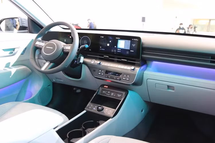 Cần số được chuyển vị trí về cột vô-lăng để lược giản thiết kế cụm điều khiển trung tâm, nhờ thế cũng tạo không gian để đồ rộng rãi hơn giữa 2 ghế trước có thể làm khay đựng cốc hoặc ngăn lớn đựng túi xách người dùng. Nhờ chiều dài cơ sở lớn hơn so với thế hệ cũ nên không gian nội thất của Hyundai Kona 2024 cũng rộng rãi hơn.