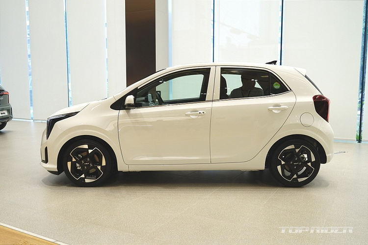 Tiếp theo là cản trước mới với hốc gió trung tâm rộng và khe gió nằm dọc ở hai góc. Ở bên sườn, Kia Morning 2024 không thay đổi thiết kế, trừ vành la-zăng. La-zăng của mẫu xe này sở hữu đường kính lớn nhất lên đến 16 inch. Trong khi đó, gương chiếu hậu của xe có thể tự động gập khi khóa cửa.