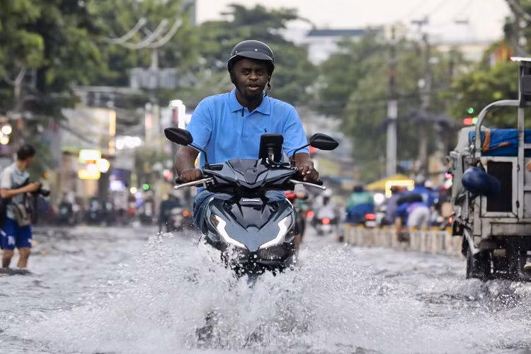 Nhiều người phải rất vất vả mới điều khiển được xe máy thoát ra được vùng ngập. Phương tiện lưu thông chỉ dám đi vào phần giữa của trục đường để đảm bảo xe không bị chết máy. 