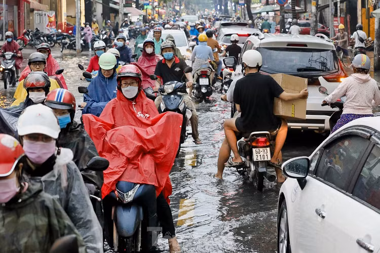 Đến gần 18h, lượng nước bắt đầu rút, người dân vội vã trở về sau khoảng thời gian đứng đợi. 