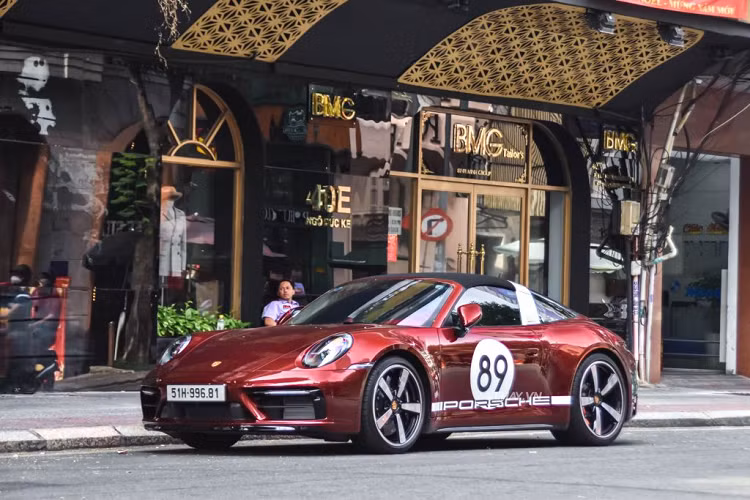 So với bản tiêu chuẩn, chiếc Porsche 911 Targa 4S Heritage Design đặc biệt này sở hữu loạt chi tiết độc quyền như màu sơn Cherry Metallic kết hợp với ô tròn số 89 màu trắng và đen ở bên hông.
