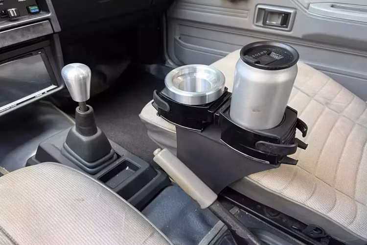 Tiếp đến là hệ thống đèn pha tròn cổ điển, đây nhiều khả năng là chi tiết đã được độ lên, cản trước của Toyota Corolla II GL 1985 rất thú vị, nó be ra và vuông vức, tạo nên sự cá tính và hầm hố cho đời này. Vòng ra bên sườn, chiếc xe của ông Đặng Lê Nguyên Vũ đã được độ lại bộ mâm. Đằng sau xe với thiết kế hatchback 3 cửa rất thú vị, cùng quả cánh gió mui xe. 