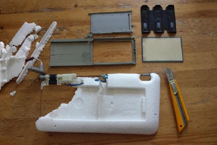 Xương gá quanh khung tấm chắn nắng ôtô được làm từ loại kim loại nhỏ và các bộ phận khác làm từ nhựa, kèm đường điện cho đèn chiếu sáng.