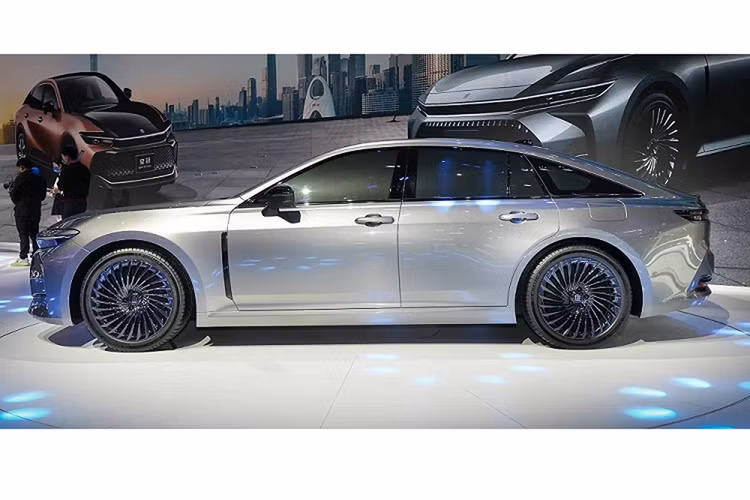 Phía sau vô lăng là bảng đồng hồ kỹ thuật số có kích thước 12,3 inch, tương đương với màn hình cảm ứng trung tâm. Vì Toyota Crown Sedan 2024 là xe dẫn động cầu sau nên bên trong nội thất có trục truyền động chạy dọc khá lớn. Chi tiết này khiến cụm điều khiển trung tâm bị đẩy lên cao, tạo thành vách ngăn giữa 2 ghế trước.