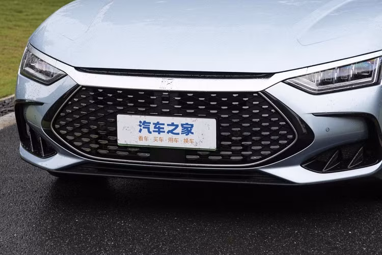 Tiếp đến, chiếc sedan hạng sang cỡ trung của BYD có lưới tản nhiệt lớn, với nan 3D ghép lại với nhau, viền trên cùng được mạ crôm nhưng 2 bên hông lại là nhựa màu đen. Hốc gió 2 bên hông của sedan hạng sang cỡ trung BYD Han DM-i Champion Edition 2023 cũng đã được thiết kế lại so với bản cũ. Phần đầu xe của BYD Han DM-i Champion Edition 2023 thiết kế hoàn toàn khác biệt so với xe thuần điện.