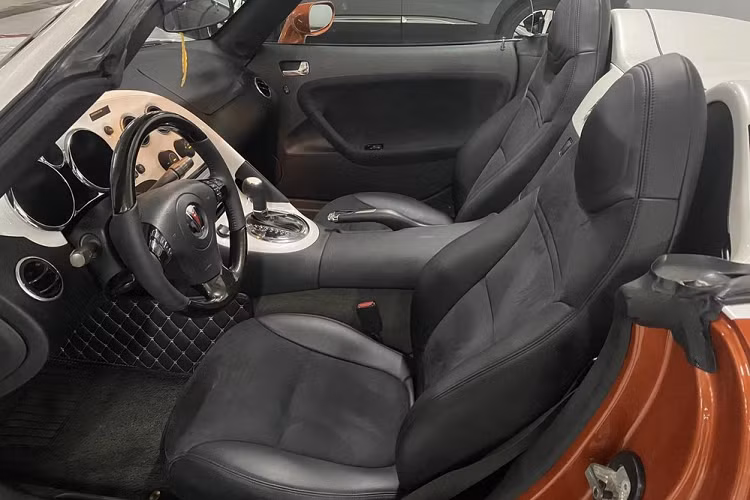 Pontiac Solstice sử dụng mui mềm, có thời gian đóng hoặc mở trong vòng hơn 20 giây. Chiếc Pontiac Solstice trong bài viết này có ngoại thất 2 màu là cam cánh gián và trắng sữa, rất đẹp mắt.