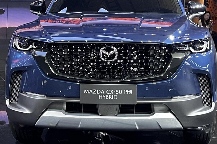 Mazda CX-50 hybrid vẫn có mặt trước áp dụng thiết kế theo phong cách gia đình mới nhất của Mazda, với lưới tản nhiệt phẳng và rộng cùng đèn pha LED hoàn toàn mới, 2 bên đầu xe có hốc gió dựng đứng, và dù mang màu mới hay cũ, cản va trước/sau, vòm bánh xe hay nẹp sườn cũng là nhựa màu đen nhám.
