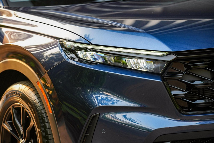 Trên cản trước của mẫu xe SUV Honda CR-V e:HEV ES 2023 cũng có hốc gió trung tâm rộng với mắt lưới hình mắt cáo sơn màu đen, khe gió nằm dọc ở hai góc và đèn sương mù LED.