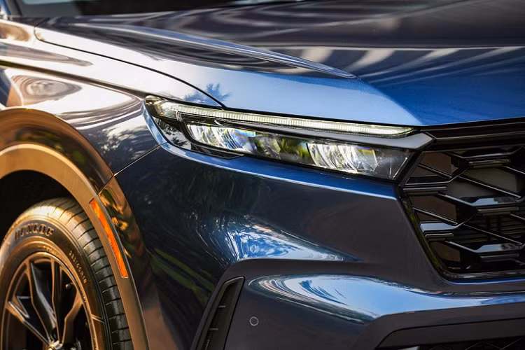 Trên cản trước của mẫu xe SUV Honda CR-V e:HEV ES 2023 cũng có hốc gió trung tâm rộng với mắt lưới hình mắt cáo sơn màu đen, khe gió nằm dọc ở hai góc và đèn sương mù LED.