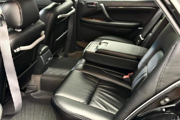 Ngoài ra bệ tì tay ở giữa có thể gập, trang bị sẵn hai hộc để cốc và khay chứa đồ cá nhân. Điều hòa được bố trí ở trần xe cùng đèn đọc sách. Là một mẫu xe gần 30 năm tuổi nên các trang bị của Toyota Crown nằm ở mức đủ dùng. Chiếc xe trong bài viết thậm chí còn giữ lại hệ thống giải trí đầu đọc đầu đọc băng cassette, ở thời điểm đó chưa có đầu đĩa CD.