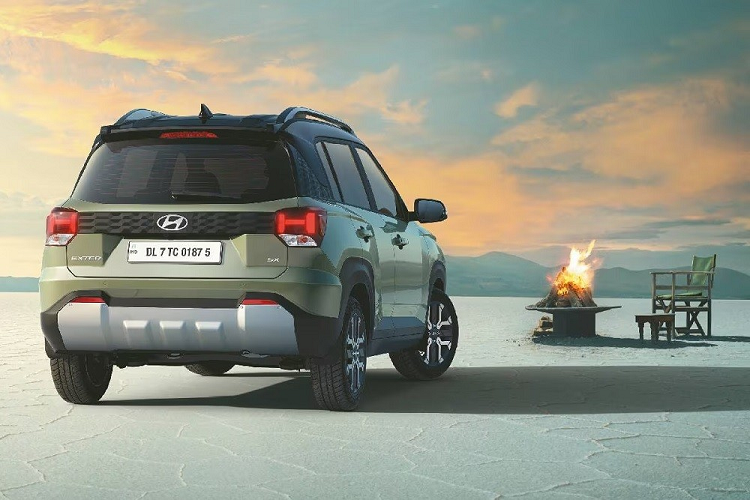 Tiếp đến là logo Hyundai dạng 2D trên nắp ca-pô, baga nóc nổi bật và hốc bánh loe rộng với ốp cua lốp màu đen. Bên trong hốc bánh này xuất hiện bộ vành hợp kim khá nhỏ với thiết kế 4 chấu kép hình chữ "Y". Tương tự cản trước, cản sau cũng đi kèm tấm ốp màu bạc bên dưới với thiết kế giả bộ khuếch tán gió thể thao. Vì được phát triển từ Hyundai Grand i10 nên Exter dự kiến sẽ dùng chung động cơ với đàn anh.