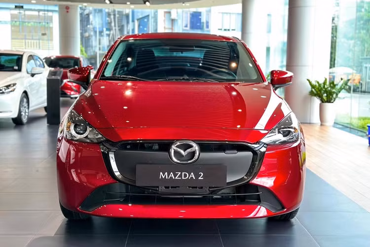 Cụ thể, Mazda2 Sedan 2023 được bổ sung lưới tản nhiệt, cản trước và vành la-zăng mới. Ở bản 1.5L AT tiêu chuẩn, xe dùng lưới tản nhiệt gần như đóng kín, lấy cảm hứng từ ô tô điện và vành hợp kim 15 inch sơn màu xám.