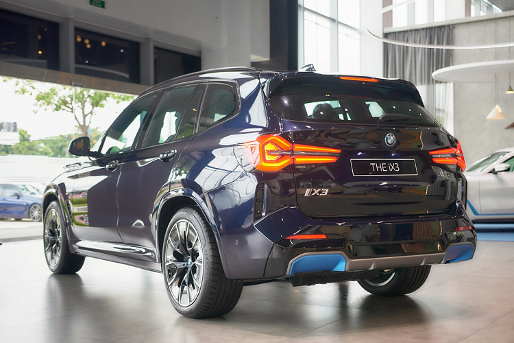Thiết kế của mẫu xe SUV điện BMW iX3 2023 nổi bật là phần cản trước của xe với lưới tản nhiệt “quả thận kép” đặc trưng, bao quanh là viền Chrome với hiệu ứng ngọc trai (Pearl-Effect) sáng bóng. Hốc gió của xe được thiết kế lớn với điểm khác biệt là viền xanh BMW i Blue để nhận biết các mẫu xe điện BMW