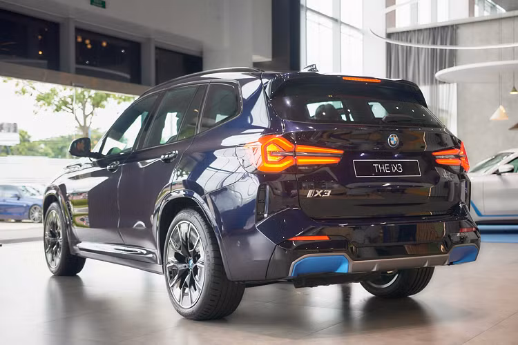Thiết kế của mẫu xe SUV điện BMW iX3 2023 nổi bật là phần cản trước của xe với lưới tản nhiệt “quả thận kép” đặc trưng, bao quanh là viền Chrome với hiệu ứng ngọc trai (Pearl-Effect) sáng bóng. Hốc gió của xe được thiết kế lớn với điểm khác biệt là viền xanh BMW i Blue để nhận biết các mẫu xe điện BMW