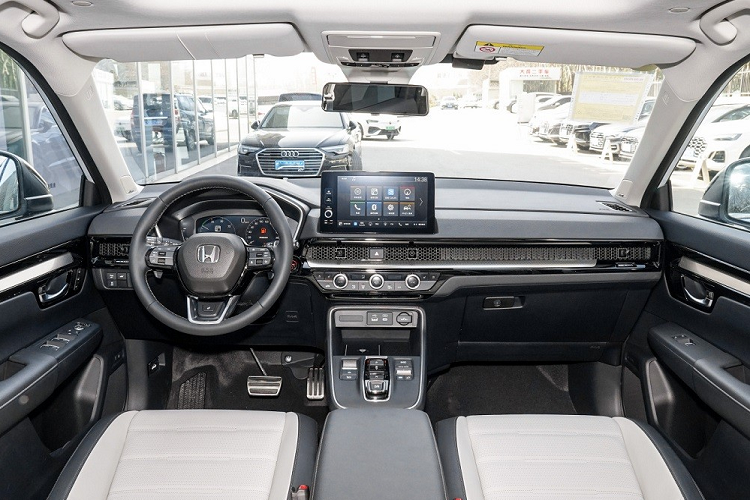 Bên trong Honda CR-V e:PHEV 2023 là không gian nội thất giống với bản thường. Xe cũng có bảng đồng hồ kỹ thuật số với màn hình LCD 10,2 inch... màn hình cảm ứng trung tâm 10,1 inch đặt nổi nhưng chưa hỗ trợ Apple CarPlay và cửa gió điều hòa kéo dài trên mặt táp-lô, trang trí bằng tấm lưới tổ ong.