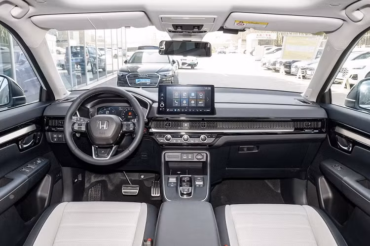 Bên trong Honda CR-V e:PHEV 2023 là không gian nội thất giống với bản thường. Xe cũng có bảng đồng hồ kỹ thuật số với màn hình LCD 10,2 inch... màn hình cảm ứng trung tâm 10,1 inch đặt nổi nhưng chưa hỗ trợ Apple CarPlay và cửa gió điều hòa kéo dài trên mặt táp-lô, trang trí bằng tấm lưới tổ ong.
