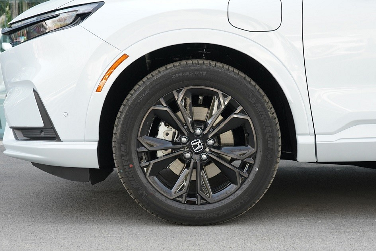 Bên sườn, Honda CR-V e:PHEV 2023 chỉ có thêm một cổng sạc ở chắn bùn trước bên trái và ốp gương ngoại thất màu đen. Xe dùng vành hợp kim 19 inch với thiết kế 5 chấu như bông hoa tương tự bản thường.