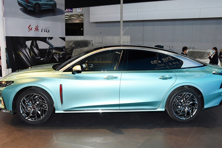 Bên sườn, ngoài phần nóc dốc với viền sơn màu bạc, Hồng Kỳ H6 2023 còn có những đường dập gân mềm mại, logo nằm dọc màu đỏ của thương hiệu Hồng Kỳ sau chắn bùn trước và nẹp mạ crôm dưới cửa.