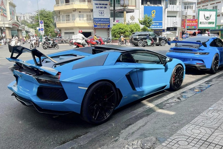 Tuy nhiên trên thực tế, màu áo của siêu xe Lamborghini Aventador LP700-4 Roadster này không phải là xanh dương mà là đỏ, ngoài ra, còn có nhiều chi tiết sơn đen bóng và điểm nhấn quan trọng nhất chính là cánh gió đuôi khổng lồ bằng carbon của xe đến từ Novitec.