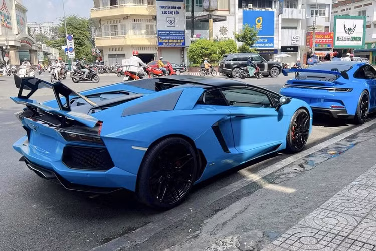 Tuy nhiên trên thực tế, màu áo của siêu xe Lamborghini Aventador LP700-4 Roadster này không phải là xanh dương mà là đỏ, ngoài ra, còn có nhiều chi tiết sơn đen bóng và điểm nhấn quan trọng nhất chính là cánh gió đuôi khổng lồ bằng carbon của xe đến từ Novitec.