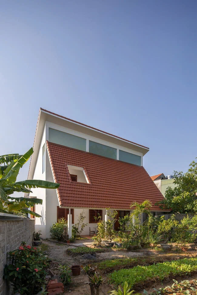 Phía sau nhà kết nối với vườn rau và chuồng gà. Mái ngói lớn, cách nhiệt nhiều lớp, cùng các khoảng mở cửa với tỉ lệ phù hợp, giúp cho các không gian trong nhà đủ sáng, đủ tối, vừa thoải mái dễ chịu vừa riêng tư. Ảnh: Hoàng Lê, Đức Ngô Bình yên và dễ chịu là điều mà có lẽ ai cũng đều cảm nhận được khi ngắm nhìn Nhà Quảng Yên. Một không gian sống đáng mơ ước, nơi có cây cối, vườn tược, hồ nước, mái ngói đỏ và hàng hiên thư thái!