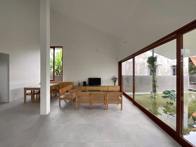 Hệ cửa kính lớn đầy chất hiện đại, trải rộng với hướng nhìn ra bể cá, hòn non bộ và cây cảnh phía trước nhà. Ảnh: Hoàng Lê, Đức Ngô