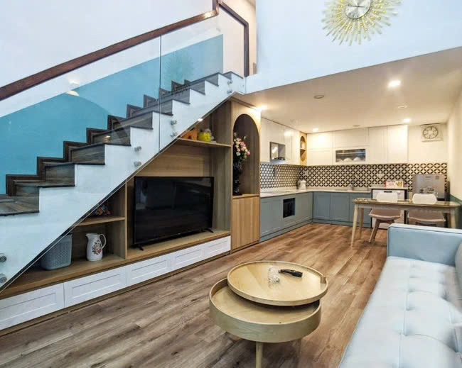 Giải pháp đẩy cầu thang về sát tường giúp tổng thể công trình có chiều sâu, trông rộng rãi hơn hiện trạng trước đây. Gầm cầu thang được tận dụng làm tủ kệ tivi rất hợp lý. Ảnh: Nguyễn Nhung