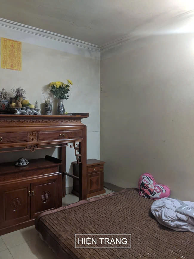 Phòng thờ cúng và giường ngủ nằm chung với nhau không phân cách. Ảnh: Nguyễn Nhung Nhóm thiết kế đã dành nhiều thời gian để nghiên cứu phương án thiết kế phù hợp với điều kiện hiện trạng của ngôi nhà. Giải pháp đầu tiên là thay đổi hệ thống cầu thang, chuyển cầu thang giữa nhà thành cầu thang 1 vế, tận dụng gầm cầu thang làm nơi để kệ tivi cho phòng khách, nhờ đó không gian nhà trông rộng rãi hơn hẳn. Bản thân gia chủ yêu thích thiết kế có đường cong, những đồ trang trí và cây cảnh nhưng do diện tích hạn chế nên thiết kế ban đầu khó đáp ứng. Với lần cải tạo này, nhóm thiết kế cố gắng tạo nhiều không gian trống để gia chủ có thể trang trí theo sở thích cá nhân. Kiến trúc sư đập bỏ bức tường phía sau ghế sofa để làm hệ kính trong, bức tường kính khiến căn phòng trông rộng hơn và trở thành điểm nhấn cho phòng khách.