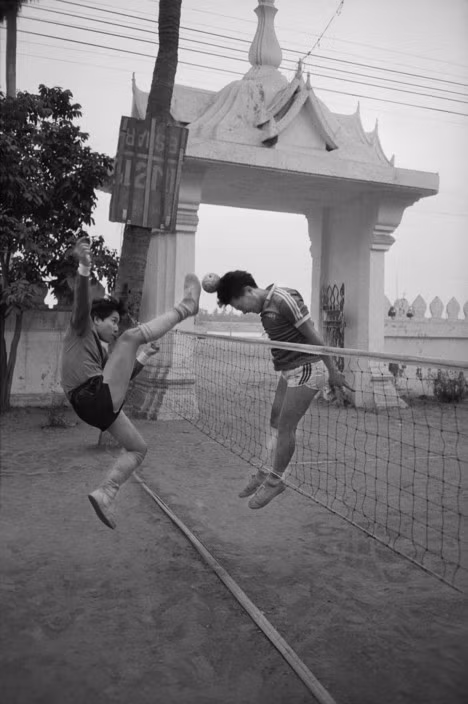Các thanh niên thi đấu Sepak Takraw (cầu mây) tại sân một ngôi chùa ở Vientiane, 8/4/1993. Ảnh: John Vink / Magnum Photos.
