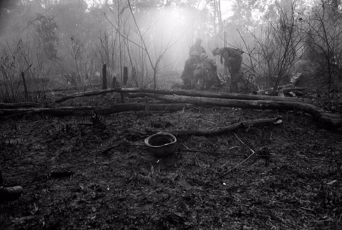 Lính Mỹ đưa đồng đội bị thương vào một điểm tập kết trong rừng. Ảnh: Catherine Leroy.
