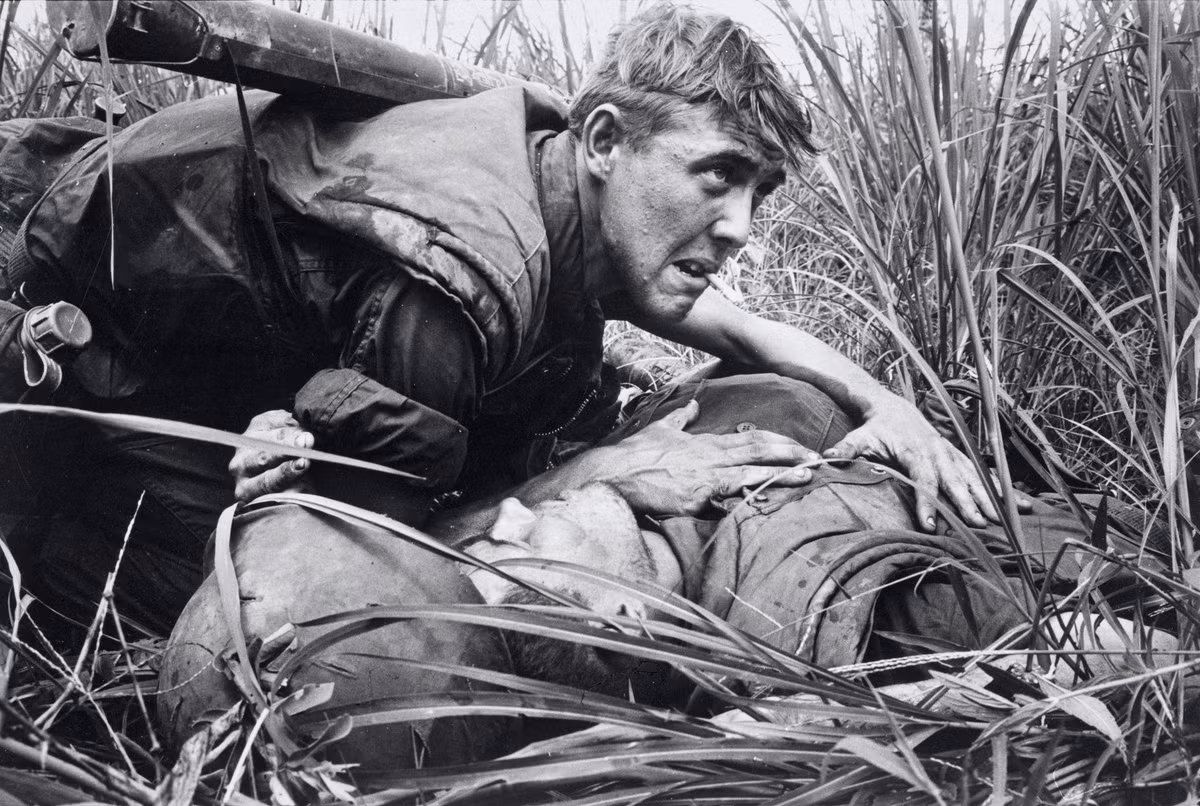 Một người lính bên đồng đội bị thương. Ảnh: Catherine Leroy.