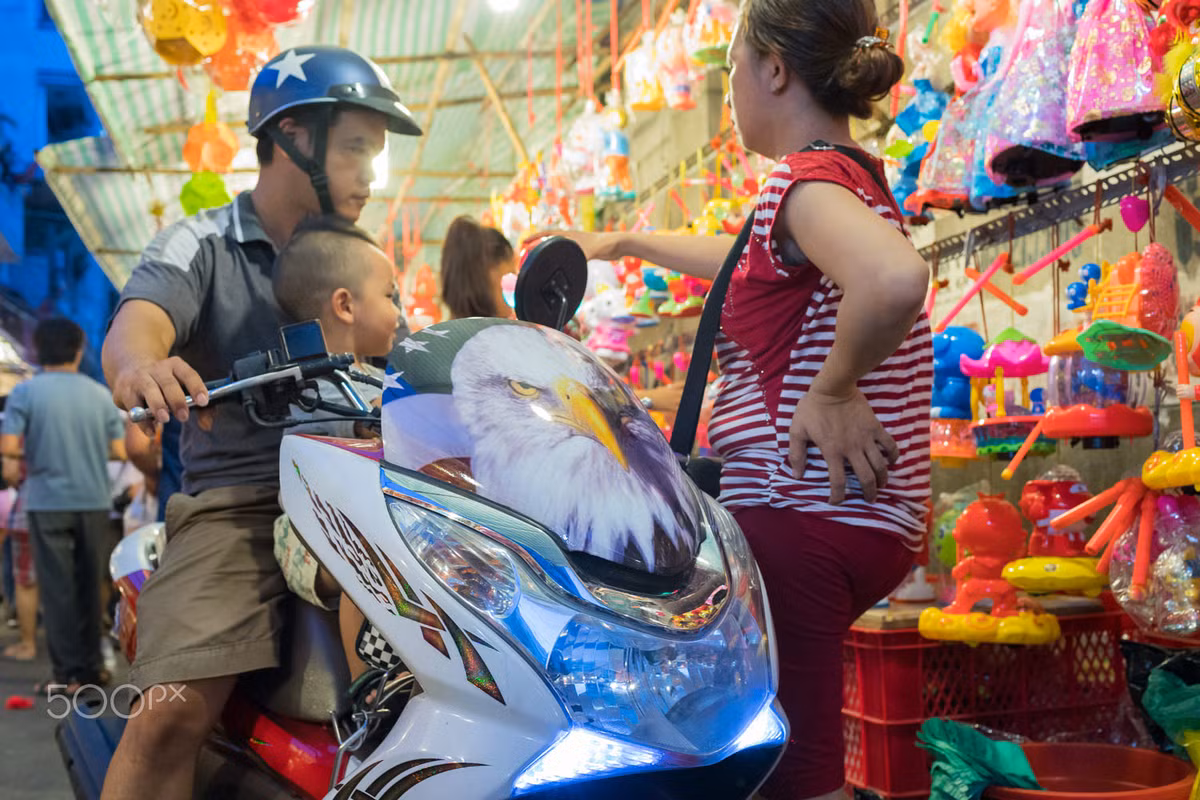 Một ông bố đưa con nhỏ đi chơi Trung thu trên xe máy. Ảnh: Yan Lerval/ 500px.com.